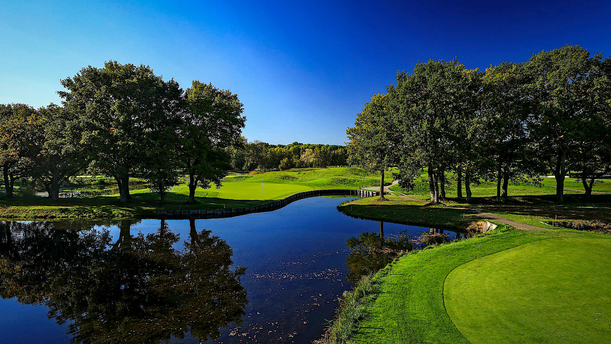 Reshaped in 2004, the 13th offers a very narrow route to its fairway. This dogleg-right is a technical and demanding hole. If your tee shot is not long enough, you will find yourself with an almost impossible second shot to the well-protected green. Not only do you have to carry the water in front, but you also have to avoid the oak trees guarding the green. (Source: PGA of America)