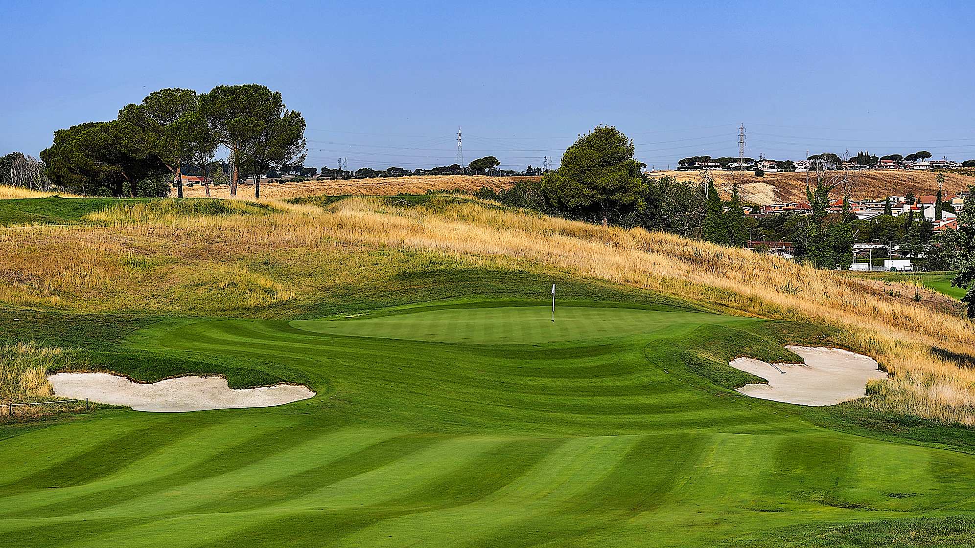 Experienced players can try to pass over the bunker on the left corner of the hole and then play a second shot with a short iron. Those who prefer to play if safe should stay on the right side of the fairway, then will have to face a second shot with a long iron, or possibly decide to lean on the apron with a layup avoiding the risk of ending in the deep bunker on the right side.