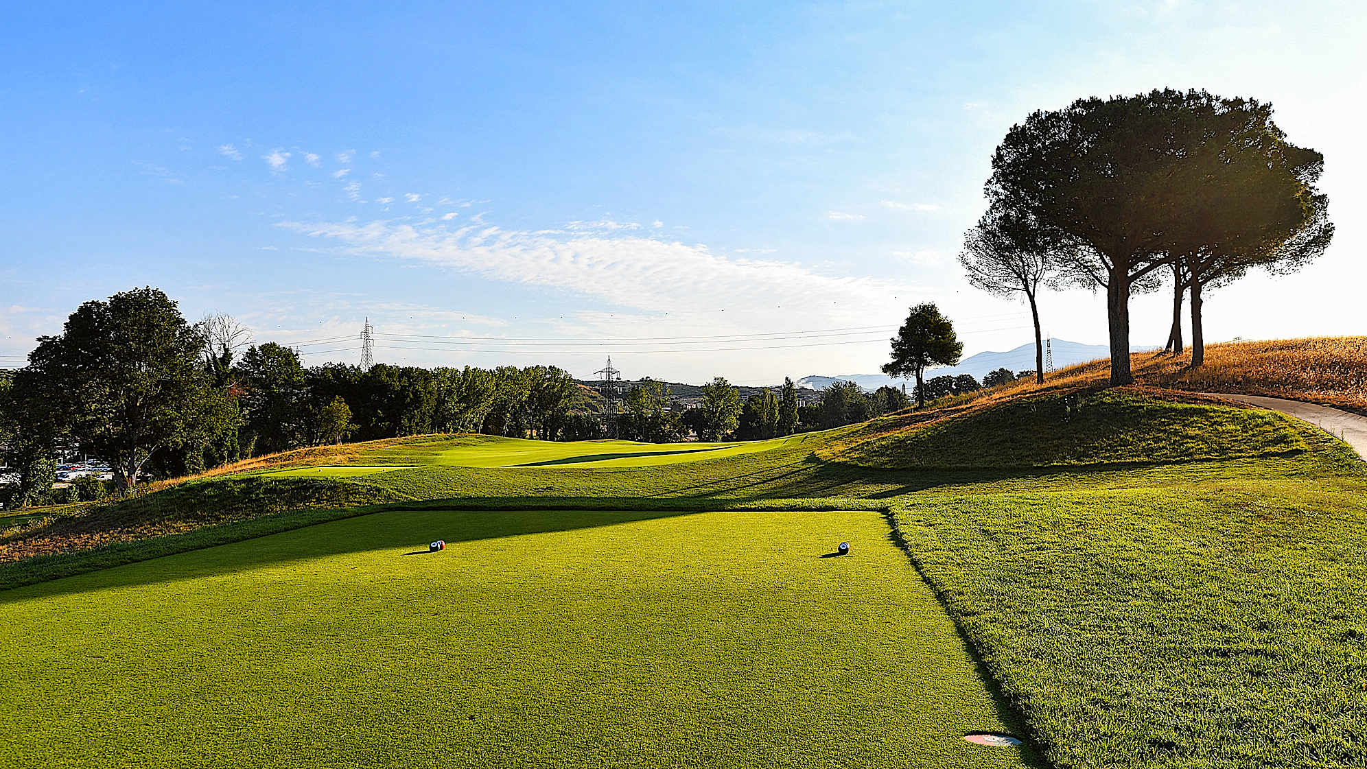 Strong players can try to cut the right corner of the dogleg, paying attention to the rough, and reach the green with a shorter iron. Those who choose the centre of the fairway will have a long second shot to reach the green which is well protected on the front left side by two bunkers.