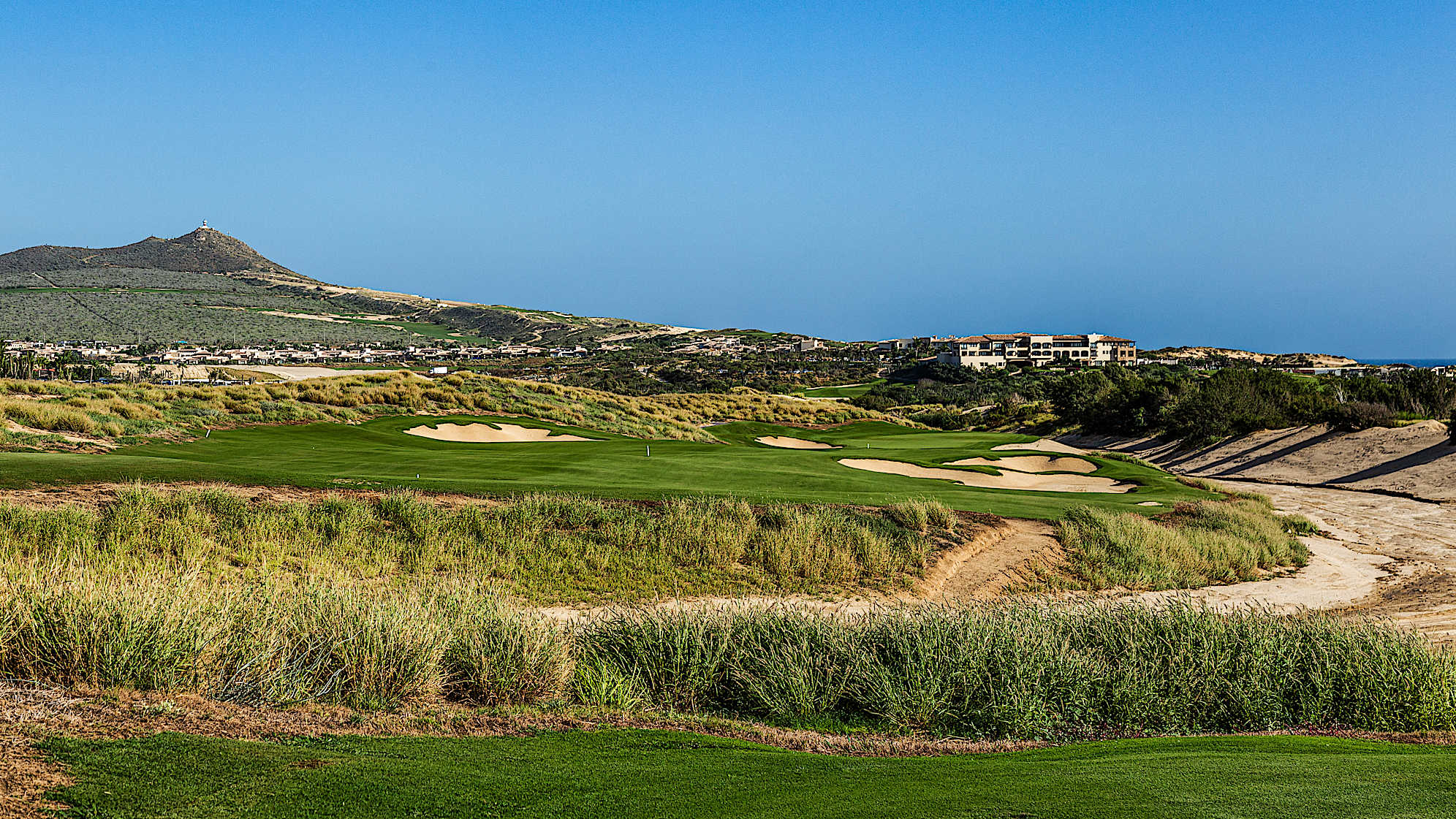 After a change in direction, playing with the prevailing wind introduces a new challenge: a desert arroyo. Carrying the right fairway bunkers near the arroyo yields an open approach to the green. Shots aimed left must carry a bunker short of the green. The sandy arroyo protects the green's right side and an elevated pin area at the back demands a precise and bold approach.