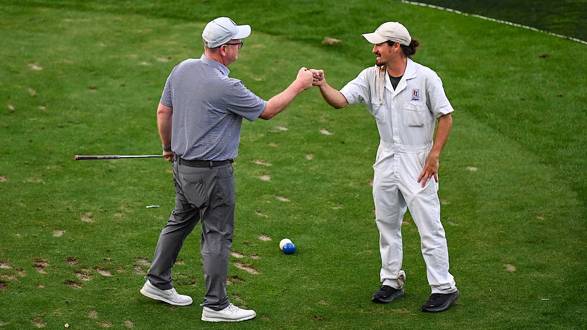 A golfer receives a fist bump from a caddie on the 17th hole on the Stadium Course at TPC Sawgrass, home of THE PLAYERS Championship, on January 20, 2023 in Ponte Vedra Beach, Florida. (Photo by Keyur Khamar/PGA TOUR via Getty Images)