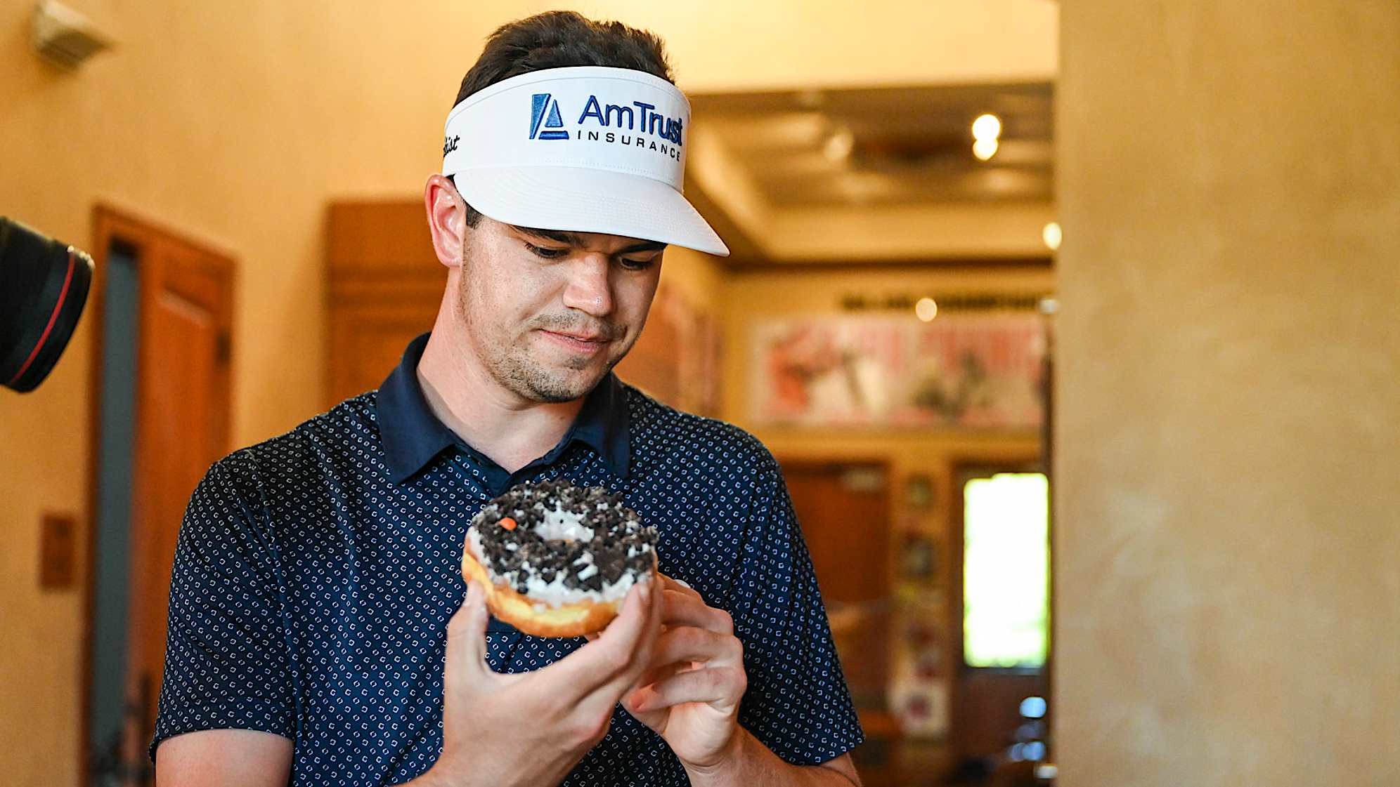 AUSTIN, TX - MARCH 25: Beau Hossler taste-tests a spread of donuts at the practice facility at the University of Texas (UT) Golf Club on March 25, 2023 in Austin, Texas. (Photo by Keyur Khamar/PGA TOUR via Getty Images)
