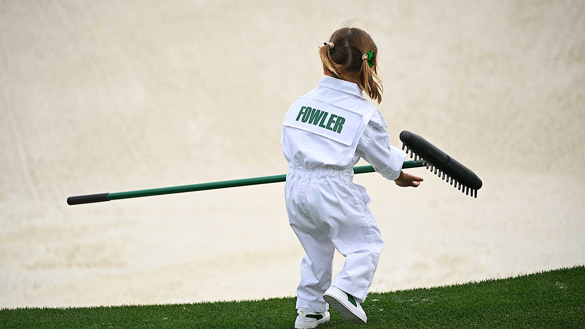 Maya Fowler readies to rake a bunker at the Masters Par 3 Contest. (Ben Jared/PGA TOUR)