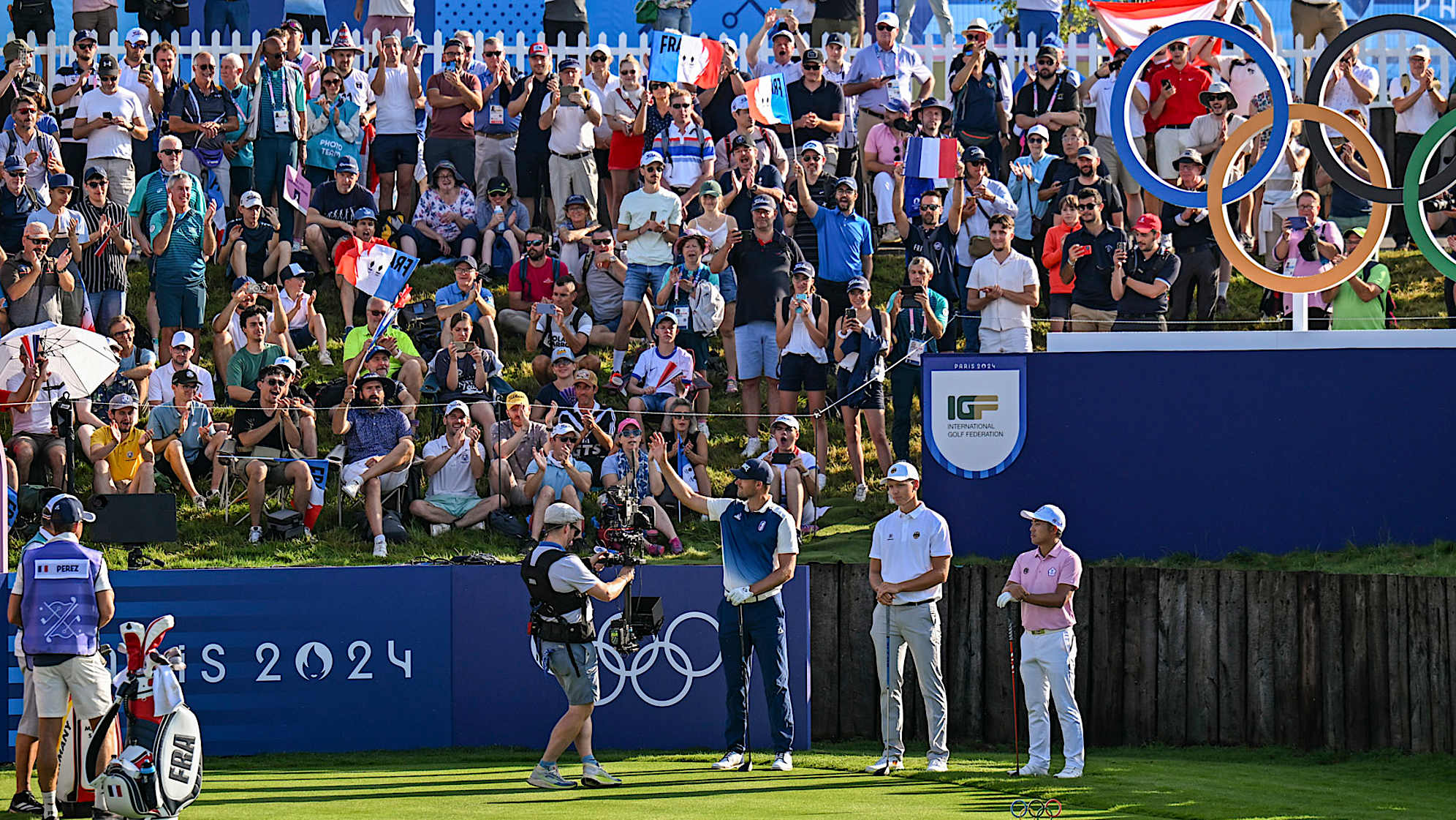 Victor Perez of Team France acknowledges fans waving French flags on the first tee during the first round of the Olympic men’s golf competition. (Keyur Khamar/PGA TOUR)