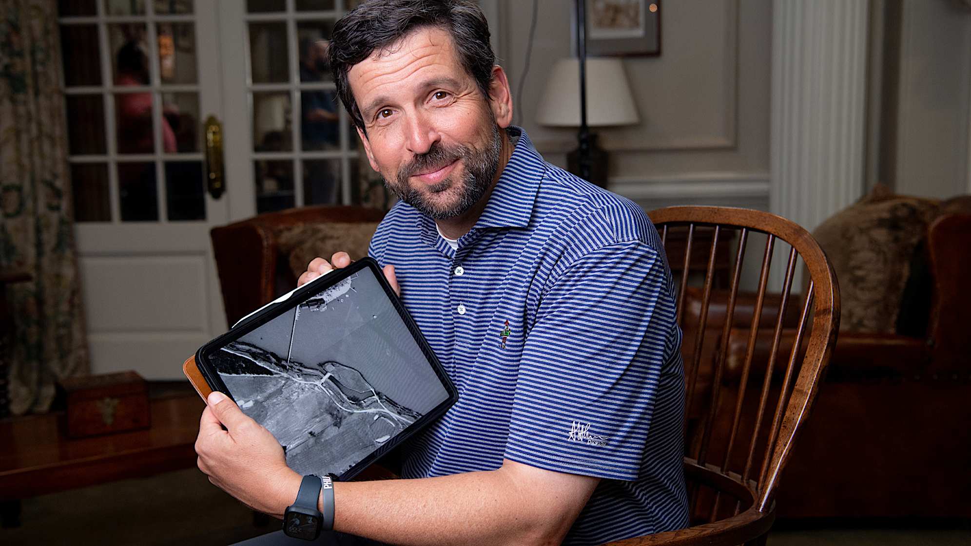 Andrew Green posing with the 1949 aerial of East Lake Golf Club. (Kate Awtrey)