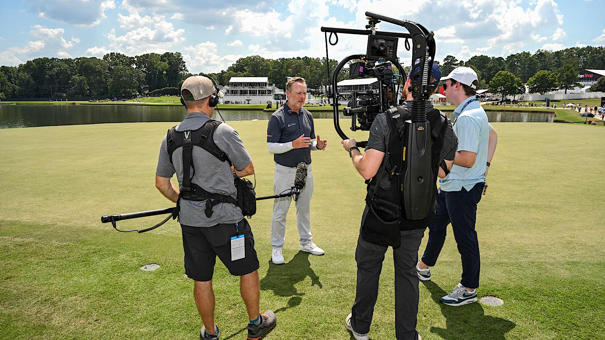 Behind the scenes as putting coach Phil Kenyon (second from the left) speaks with PGATOUR.COM writer Paul Hodowanic (right) during the first round of the TOUR Championship at East Lake Golf Club. (Keyur Khamar/PGA TOUR)