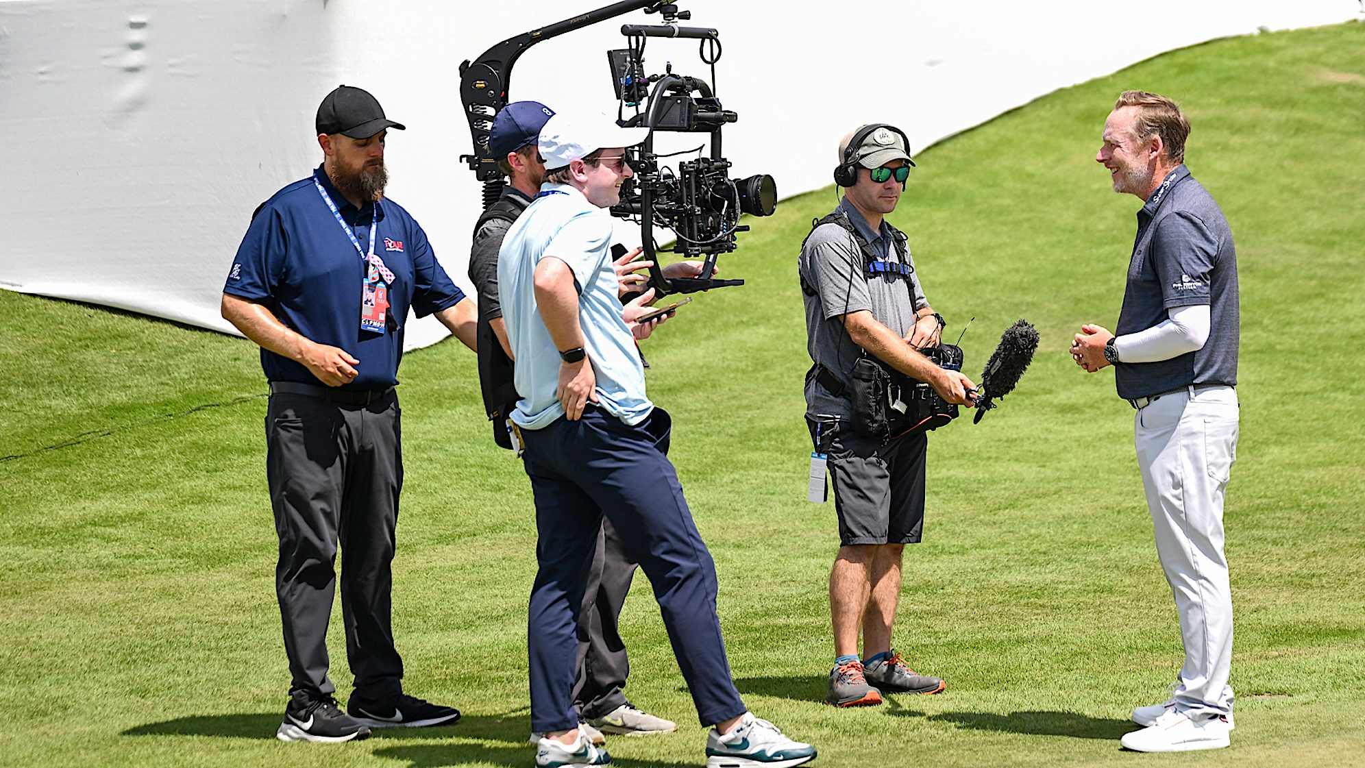 Behind the scenes as putting coach Phil Kenyon (right) speaks with PGATOUR.COM writer Paul Hodowanic (front, second to the left) during the first round of the TOUR Championship at East Lake Golf Club. (Keyur Khamar/PGA TOUR)