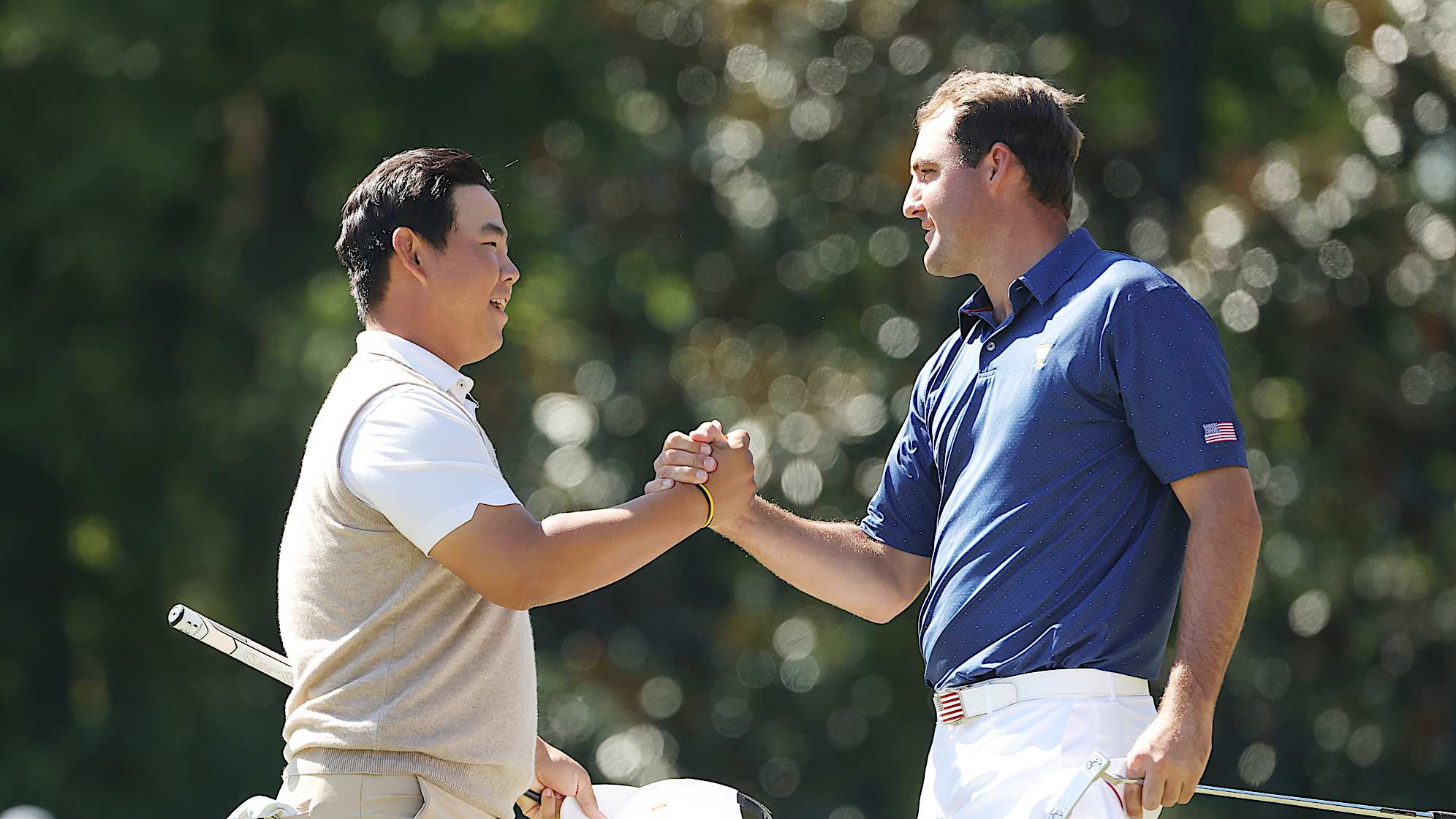 The International Team's Tom Kim and the U.S. Team's Scottie Scheffler shake hands at the 2022 Presidents Cup at Quail Hollow. (Stacy Revere/Getty Images)