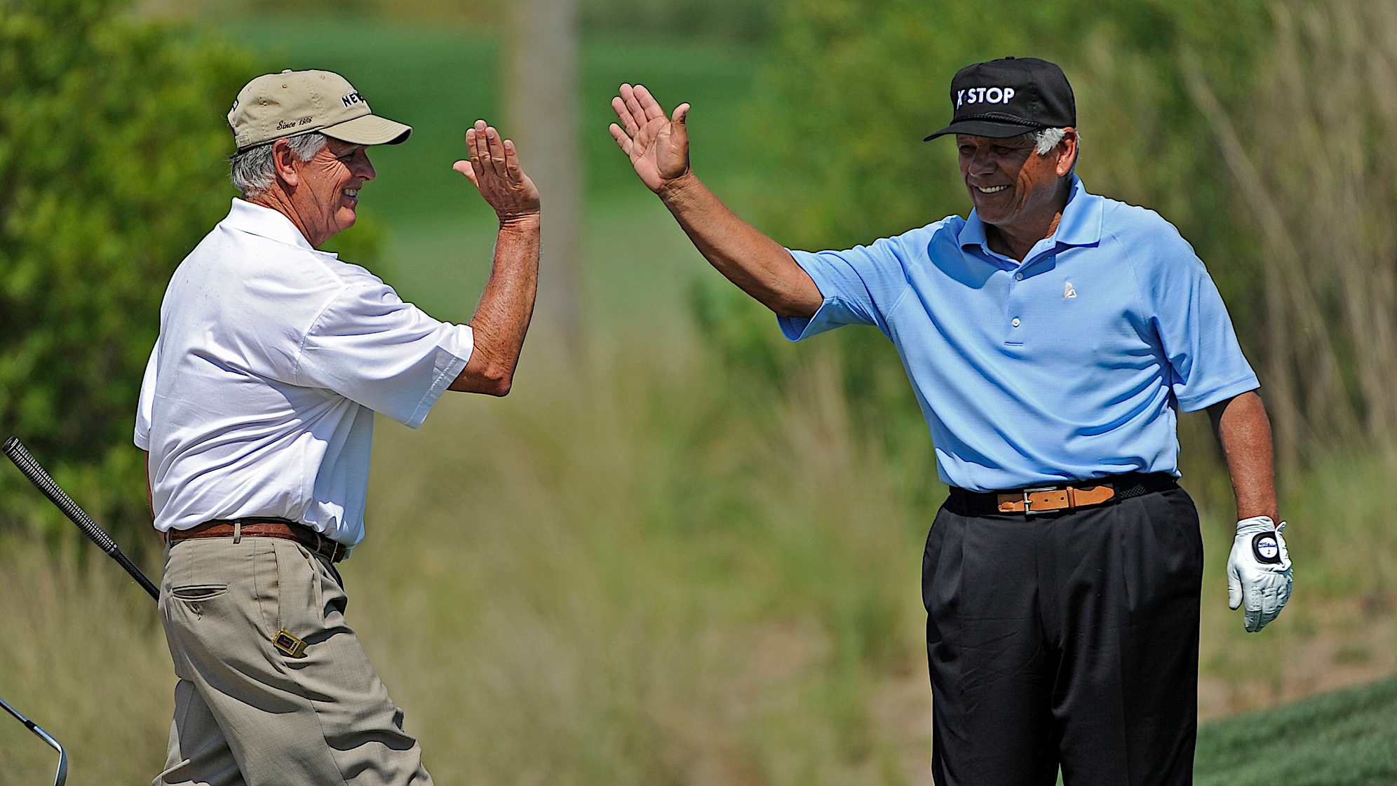 Lee Trevino (right) high-fives playing partner Mike Hill on the 18th green during the Raphael Division at the Liberty Mutual Legends of Golf in 2009. (Chris Condon/PGA TOUR)
