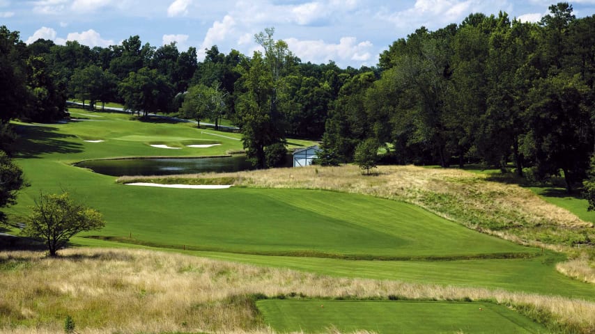 The downhill tee shot must avoid a small creek on the left and a large fairway bunker on the right. Going for the green in two will require a long carry over water and deep greenside bunkering to a severe back to front sloping green.