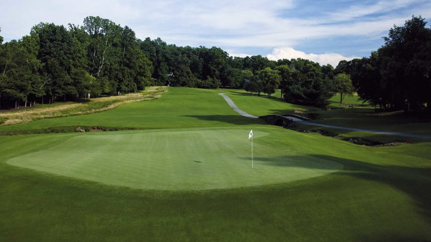 A long downhill tee shot to a bunkerless "punchbowl" green must avoid the creek crossing in front and on both sides.