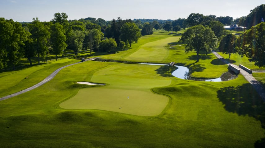 Ben Hogan once called this hole the toughest opening test in championship golf. The opening tee shot is from an elevated tee to a slight dogleg-left. A great drive can take advantage of a fairway down slope at 290 yards. Allens Creek runs across the fairway hole at the 360 mark. The danger off the tee is out of bounds to the right and three bunkers on the left. The green is well guarded by grass hummocks and a greenside bunker short right. (Source: PGA of America)