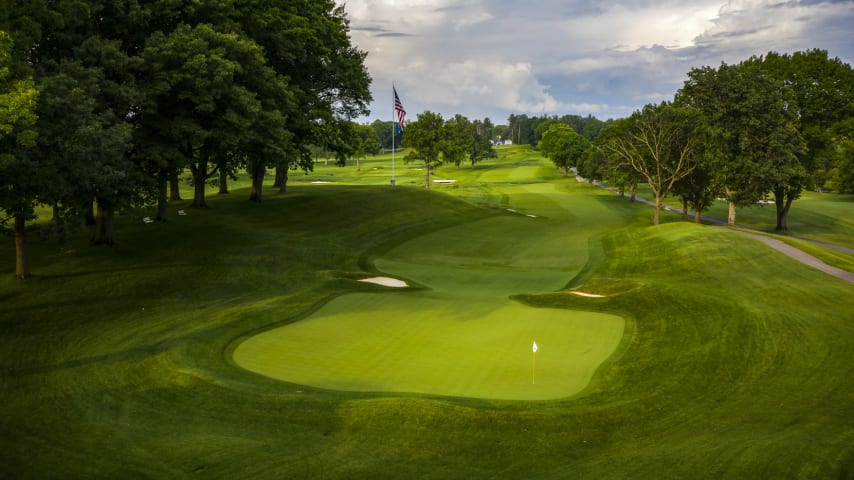 Oak Hill’s most notable par 5 heads back uphill towards the clubhouse. Allens Creek crosses the fairway at the 325 mark, which will force most players to layup short. A tee shot short of Allens Creek leaves the player with 300 yards to the hole uphill. Two fairway bunkers guard the right side of the fairway 125 yards out. The green sits in a hollow, providing patrons a beautiful amphitheater setting. (Source: PGA of America)