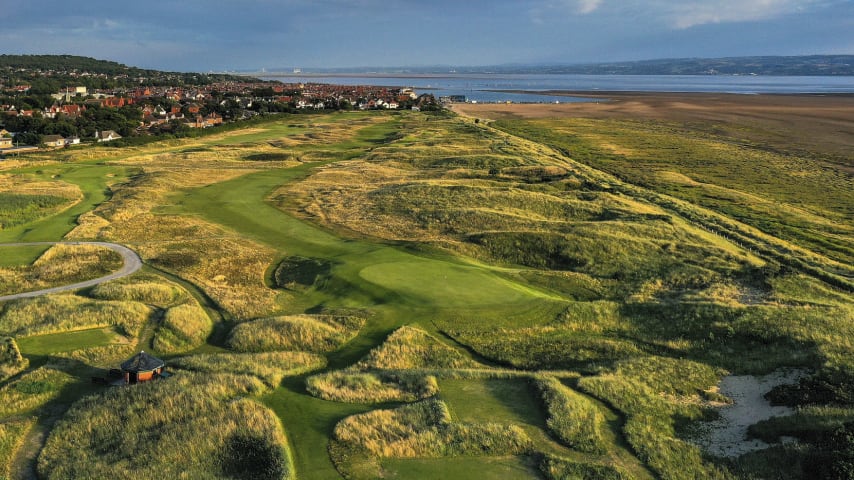 The 12th continues round to the left, running along the shoreline, doglegging that way with the fairway cambering slightly left to right. Three bunkers lie in wait to the right-hand side for aggressive tee shots that are leaked out that way. Depending on the wind, longer hitters could be able to take the bunkers out of play with a right to left shape up the hole, but a sea of rough all down the left-hand side makes that option risky. Once the fairway is found, a tough approach can also await depending on the pin. The green is raised significantly from the fairway, and is very long in length. Pins at the front are very accessible where the green is at its widest, but the further back the flag, the tougher the shot, as a huge run-off area to the left creeps in to the back of the green which can become quite tight, with misses to the right and long also leaving very difficult up and downs. (Source: R&A)