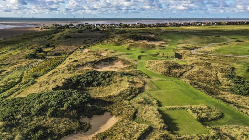 The favourite hole of many members at Royal Liverpool, the par-3 13th is a stunning hole that employs optical illusions to only add to the difficulty. From the tee it appears as if there is no room to the left, with only far-right pins fully visible, and the undulation of mounds 100 yards away blocking the view, leaving the impression that left is a no-go zone. In some ways that is true, with rough hillocks and difficult lies awaiting down that side, but there is considerably more room than first appears. The green runs diagonally from right to left, with a bail-out zone short and right. Anything pin-high right, however, can find significant trouble with a bunker to the right and a gnarly hill, from where an up and down is extremely difficult, that comes into play more than would be expected. (Source: R&A)