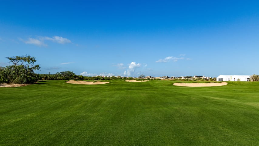 Ascending from the dunes, this lengthy par 5 requires a strategic approach due to the wide "M" shaped green protected by a large central bunker. Optimal angles for pin placements on the right side of the green are best approached from the right side of the second landing area, which in turn is accessed from the left side of the first landing area and vice versa for left pin placements. A large crowned area in the middle of the fairway adds to the challenge off the tee.