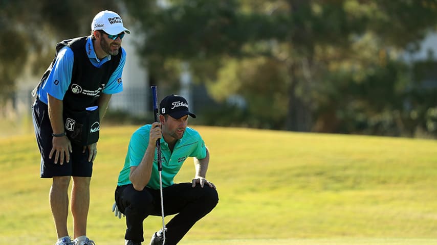 LAS VEGAS, NV - NOVEMBER 01:  Webb Simpson and his caddie Paul Tesori talk on the 10th hole green during the first round of the Shriners Hospitals for Children Open at TPC Summerlin on November 1, 2018 in Las Vegas, Nevada.  (Photo by Mike Ehrmann/Getty Images)