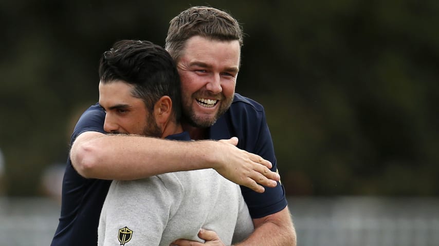 MELBOURNE, AUSTRALIA - DECEMBER 14: Marc Leishman of Australia and the International team and Abraham Ancer of Mexico and the International team celebrate after halving their match against Justin Thomas of the United States team and Rickie Fowler of the United States team during Saturday afternoon foursomes matches on day three of the 2019 Presidents Cup at Royal Melbourne Golf Course on December 14, 2019 in Melbourne, Australia. (Photo by Darrian Traynor/Getty Images)