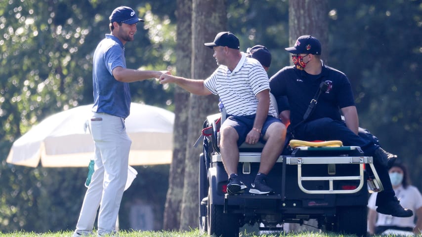 NORTON, MASSACHUSETTS - AUGUST 23: Caddie Scotty Macguiness fist bumps Scottie Scheffler of the United States as he leaves the course on a golf cart due to an injury during the final round of The Northern Trust at TPC Boston on August 23, 2020 in Norton, Massachusetts. (Photo by Rob Carr/Getty Images)