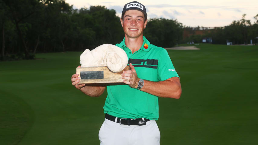 PLAYA DEL CARMEN, MEXICO - DECEMBER 06: Viktor Hovland of Norway celebrates with the winner's trophy on the 18th green after the final round of the Mayakoba Golf Classic at El Camaleón Golf Club on December 06, 2020 in Playa del Carmen, Mexico. (Photo by Hector Vivas/Getty Images)