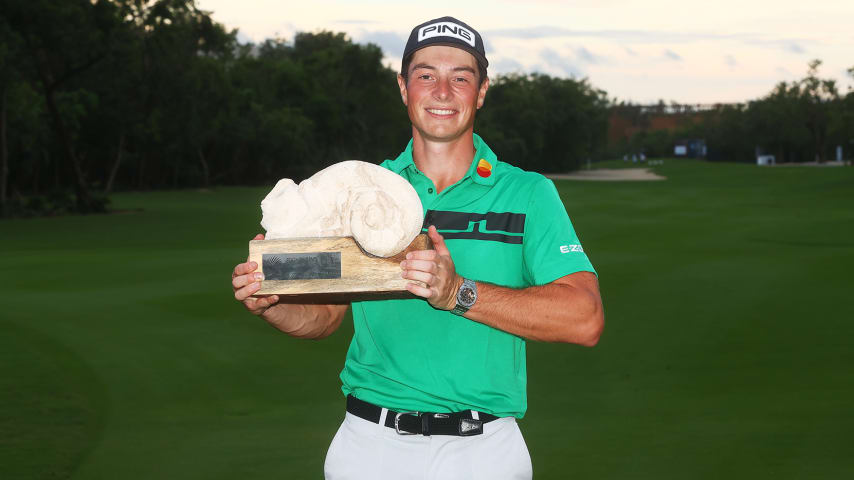 PLAYA DEL CARMEN, MEXICO - DECEMBER 06: Viktor Hovland of Norway celebrates with the winner's trophy on the 18th green after the final round of the Mayakoba Golf Classic at El Camaleón Golf Club on December 06, 2020 in Playa del Carmen, Mexico. (Photo by Hector Vivas/Getty Images)