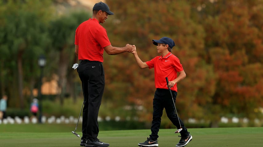 ORLANDO, FLORIDA - DECEMBER 20: Tiger Woods of the United States and son Charlie Woods fist bump on the 18th hole during the final round of the PNC Championship at the Ritz Carlton Golf Club on December 20, 2020 in Orlando, Florida. (Photo by Mike Ehrmann/Getty Images)