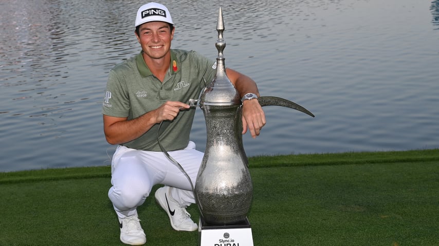 DUBAI, UNITED ARAB EMIRATES - JANUARY 30: Viktor Hovland of Norway celebrates with the winners trophy after the final round of the Slync.io Dubai Desert Classic at Emirates Golf Club on January 30, 2022 in Dubai, United Arab Emirates. (Photo by Ross Kinnaird/Getty Images)