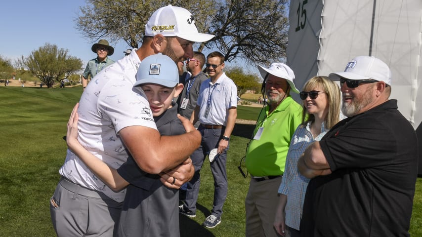 SCOTTSDALE, AZ - FEBRUARY 09:  Jon Rahm of Spain with Phoenix Small, a patient with Salt Lake City Shriners Hospital, prior to the WM Phoenix Open at TPC Scottsdale on February 9, 2022 in Scottsdale, Arizona. (Photo by Tracy Wilcox/PGA TOUR)