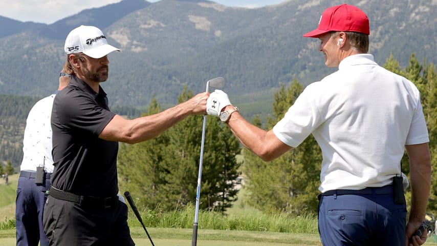 BIG SKY, MONTANA - JULY 06: Aaron Rodgers (L) and Tom Brady fist bump on the second tee during Capital One's The Match at The Reserve at Moonlight Basin on July 06, 2021 in Big Sky, Montana. (Photo by Stacy Revere/Getty Images for The Match)