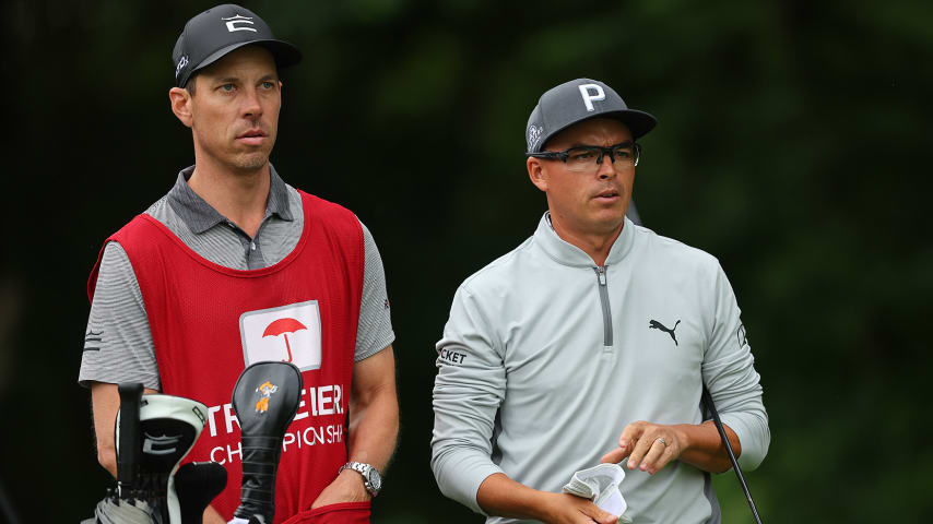 CROMWELL, CONNECTICUT - JUNE 22: Rickie Fowler of the United States talks with his caddie Joe Skovron on the 12th hole during a practice round prior to the Travelers Championship at TPC River Highlands on June 22, 2022 in Cromwell, Connecticut. (Photo by Michael Reaves/Getty Images)