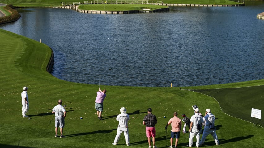 A player tees off on the 17th hole as his friends and caddies watch him on the Stadium Course at TPC Sawgrass, home of THE PLAYERS Championship, on January 20, 2023 in Ponte Vedra Beach, Florida. (Photo by Keyur Khamar/PGA TOUR via Getty Images)