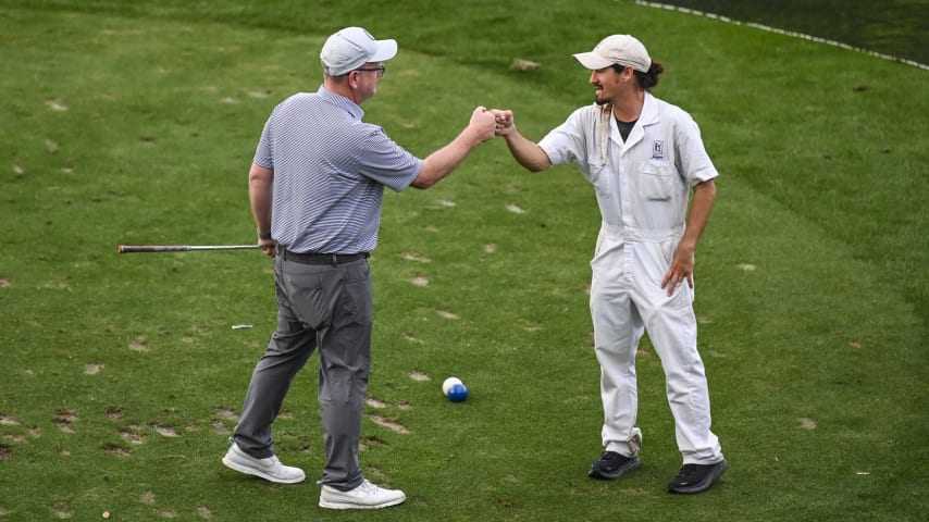 A golfer receives a fist bump from a caddie on the 17th hole on the Stadium Course at TPC Sawgrass, home of THE PLAYERS Championship, on January 20, 2023 in Ponte Vedra Beach, Florida. (Photo by Keyur Khamar/PGA TOUR via Getty Images)
