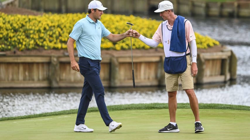 PONTE VEDRA BEACH, FLORIDA - MARCH 12:  Scottie Scheffler fist bumps his caddie Ted Scott on the 17th hole green during the final round of THE PLAYERS Championship on the Stadium Course at TPC Sawgrass on March 12, 2023 in Ponte Vedra Beach, Florida. (Photo by Keyur KhamarPGA TOUR via Getty Images)