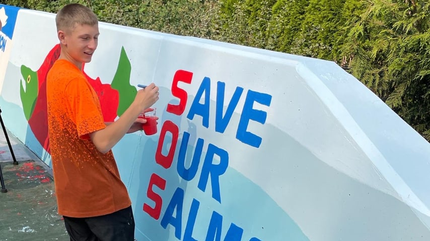 Austin Picinich paints the Save Our Salmon” (SOS) Mural along Juanita Creek , Seattle. (Courtesy Austin Picinich)
