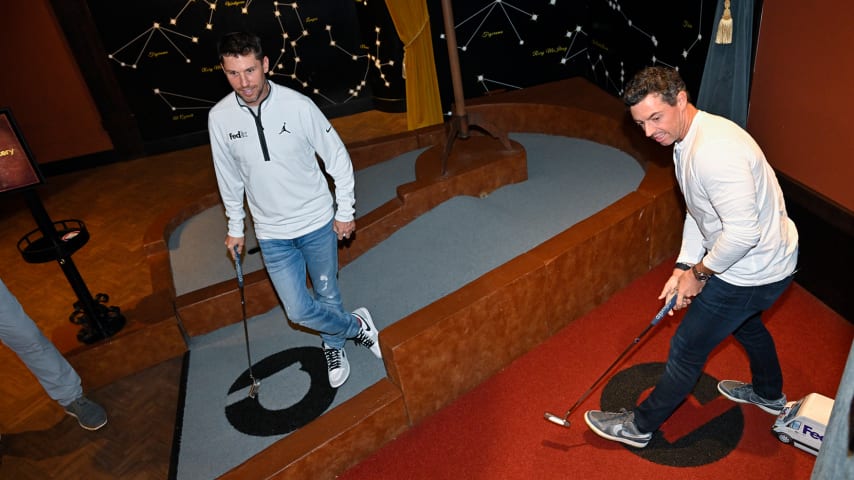 FedExCup Champion, Rory McIlroy of Northern Ireland putts as NASCAR driver, Denny Hamlin, a FedEx Ambassador, watches as the PGA TOUR Celebrates 50 Years of FedEx at Puttery on May 2, 2023 in Charlotte, North Carolina. (Ben Jared/PGA TOUR)