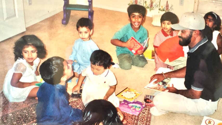 Paramjeet Ahulwalia reads to a young Sahith Theegala (green shirt) alongside friends and family. (Courtesty Paramjeet Ahulwalia)