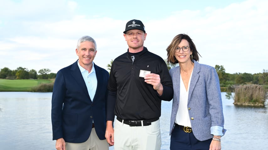 NEWBURGH, INDIANA - OCTOBER 08: Patrick Fishburn holds up his TOUR Card while posing for a photo with Commissioner Jay Monahan and President of the Korn Ferry Tour Alex Baldwin during the card ceremony after the final round of the Korn Ferry Tour Championship presented by United Leasing and Financing at Victoria National Golf Club on October 8, 2023 in Newburgh, Indiana. (Photo by Jennifer Perez/PGA TOUR)