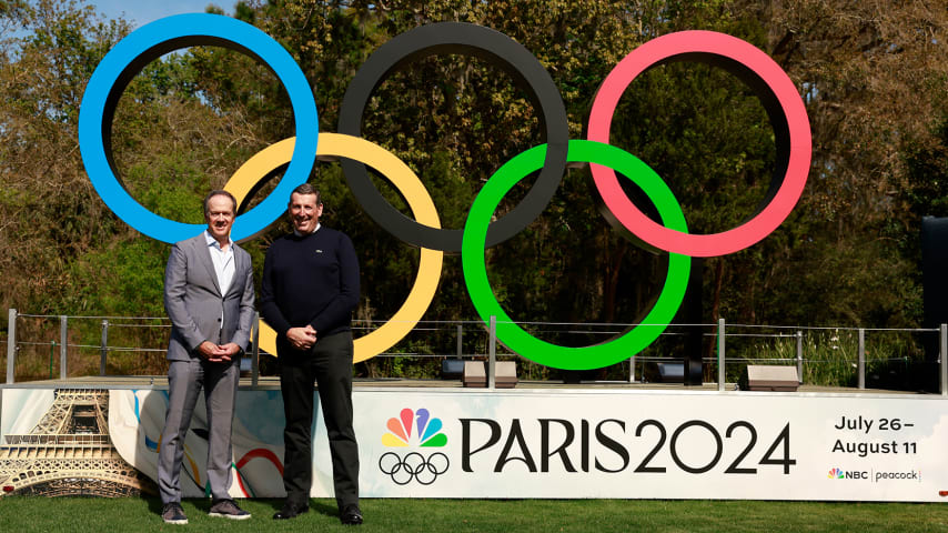 NBC Sports analyst Dan Hicks and Antony Scanlon, International Golf Federation executive director, pose in front of the Olympic rings in the Fan Village prior to THE PLAYERS Championship 2024. (Photo by Jason Miczek/PGA TOUR)