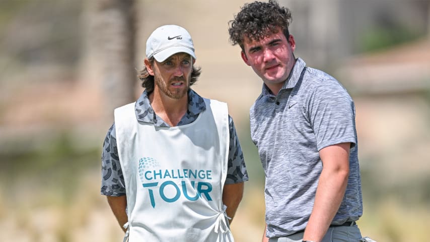 Tommy Fleetwood caddying for his stepson Oscar Craig (R) during day one of the UAE Challenge. (Octavio Passos/Getty Images)