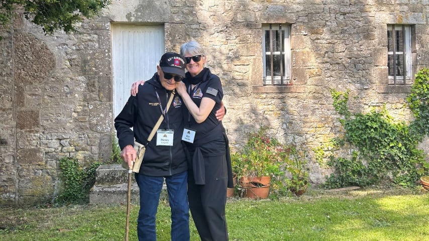 Henry Langrehr and his daughter, Kay Schneider, in Normandy, France, outside of a greenhouse that Langrehr jumped into during the events of D-Day 80 years ago. (Credit Kay Schneider)