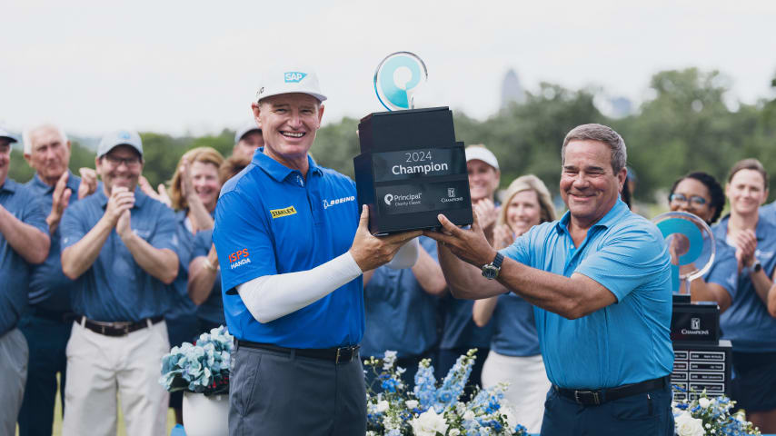 Principal Charity Classic champion Ernie Els receives trophy at closing ceremony with Dan Houston, chairman, president, and chief executive officer of Principal Financial Group. (Courtesy Principal Charity Classic)