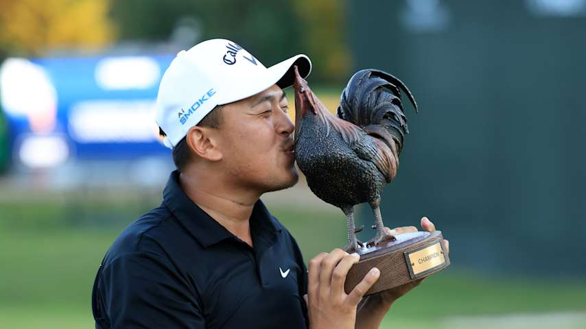 Kevin Yu gives the Sanderson Farms trophy a kiss. (Justin Casterline/Getty Images)