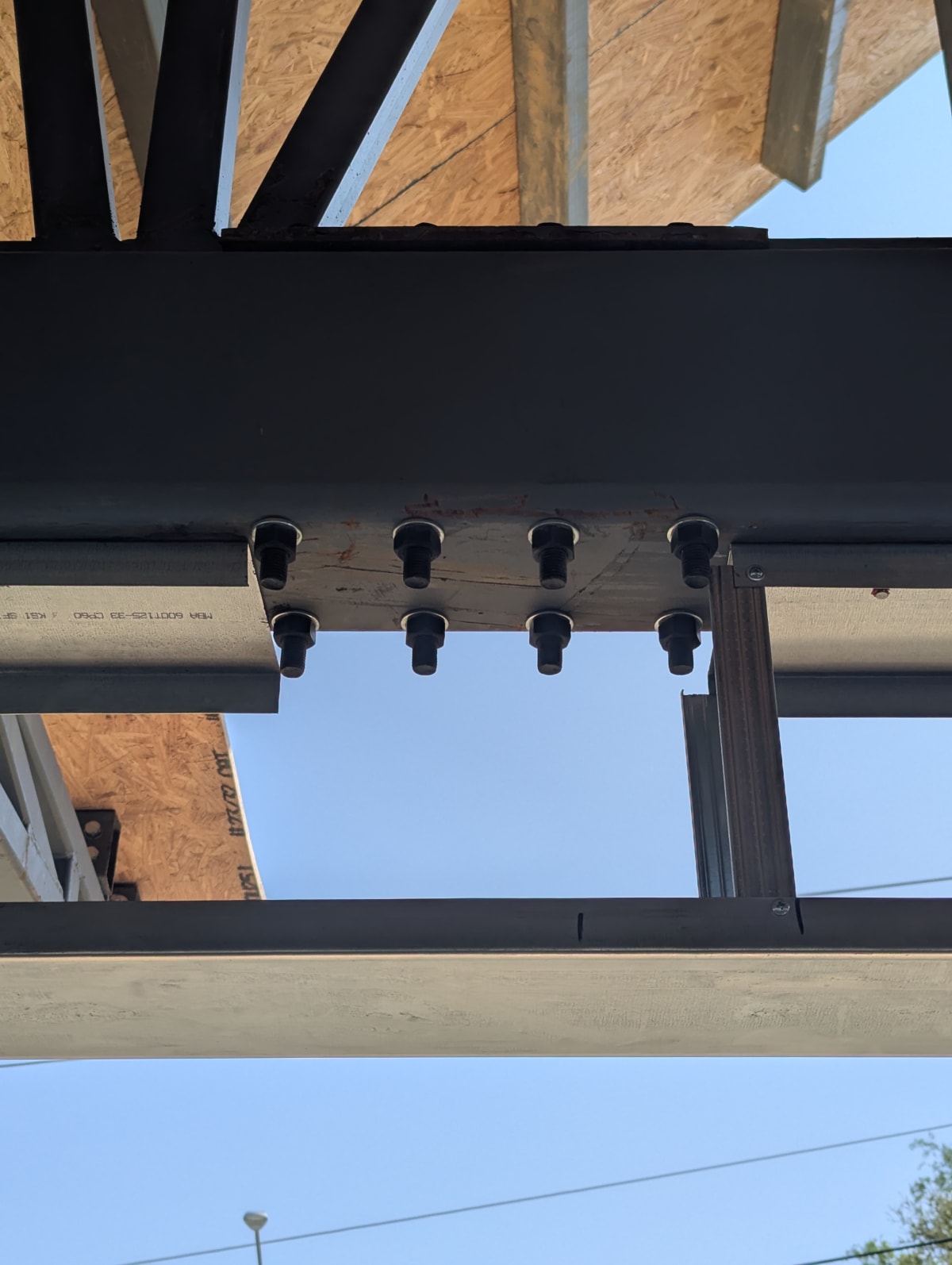 Bolted red-iron structural steel beam-to-column connection during construction of a My Castle Homes build