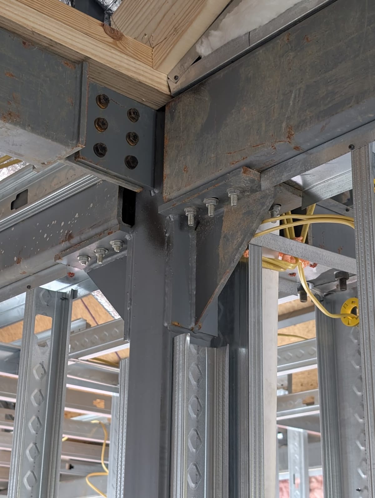 Close detail of a bolted steel structural connection, representing precision execution