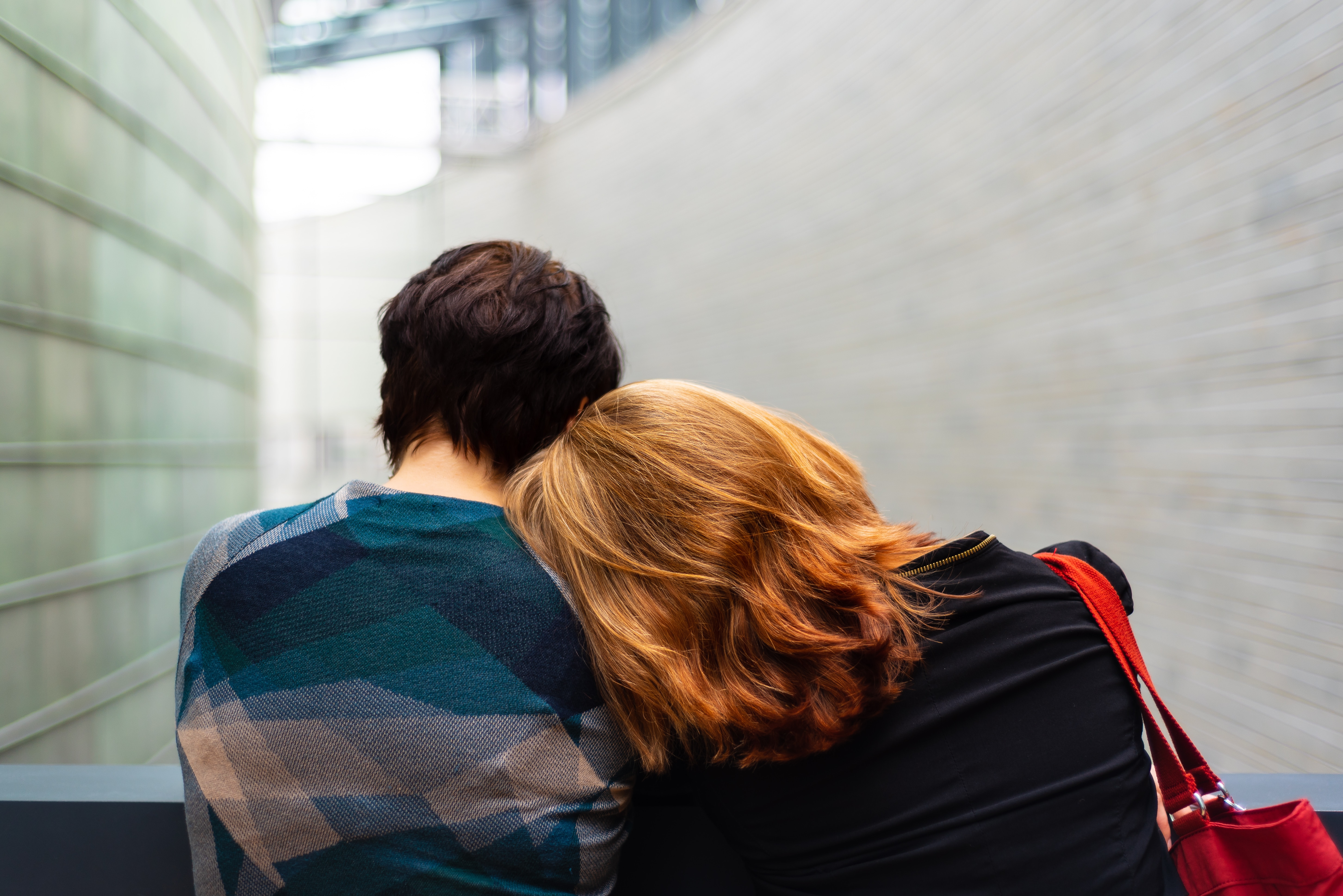 Couple standing near grey metal fence.