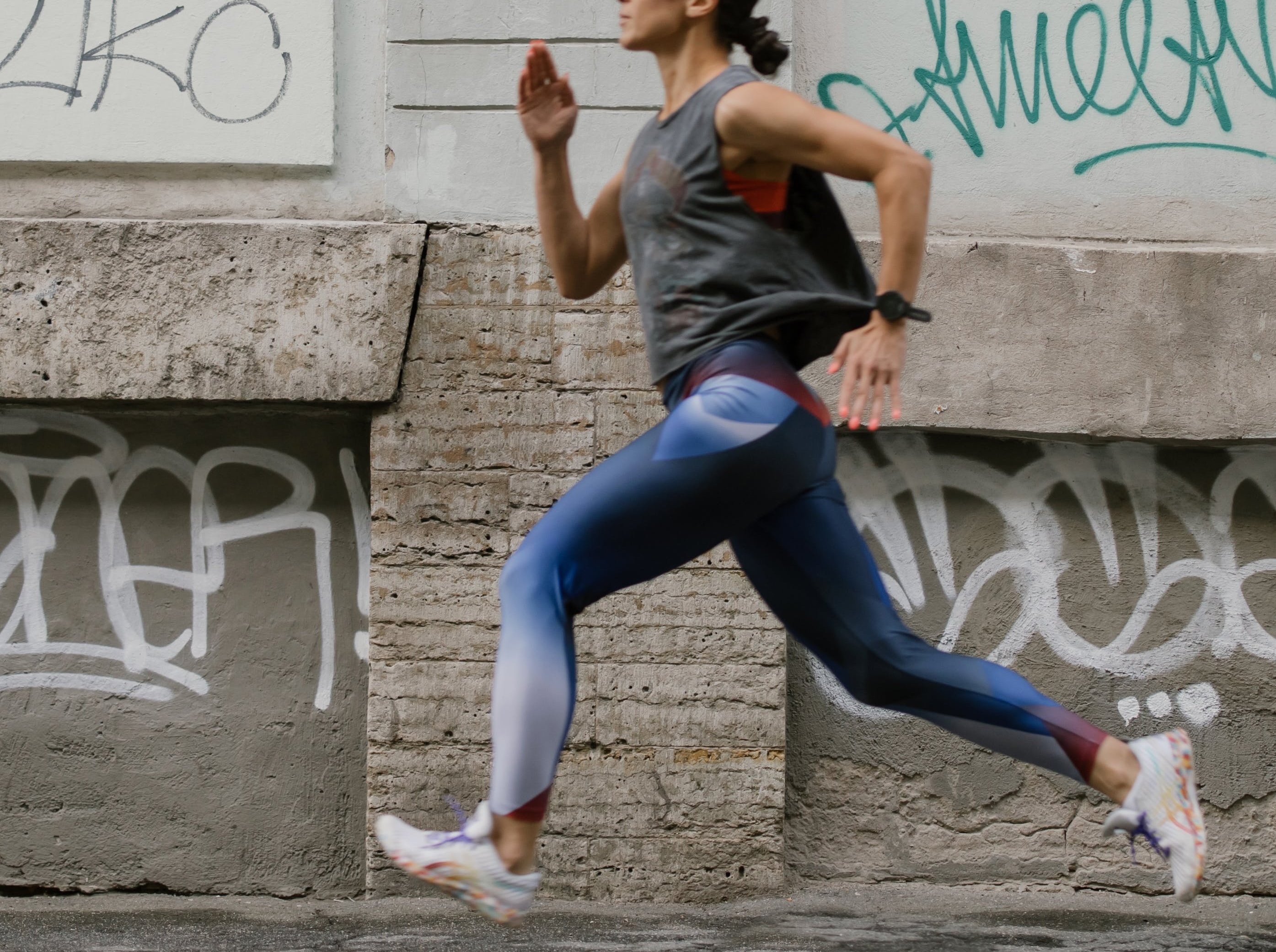 A Side View of a Woman Jogging on the Street