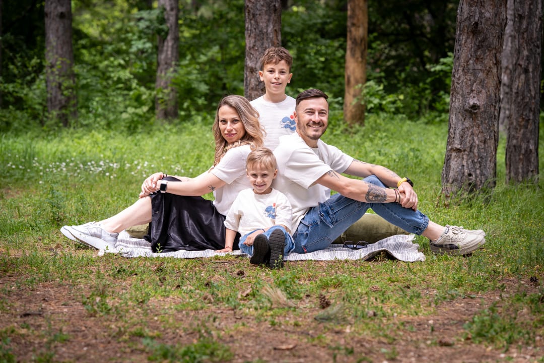 A family photo of parents and children outdoors.