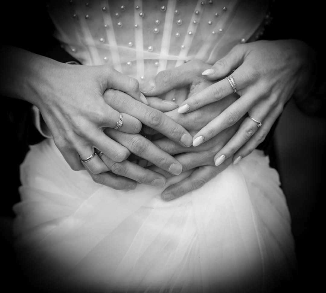Intertwined fingers and wedding rings