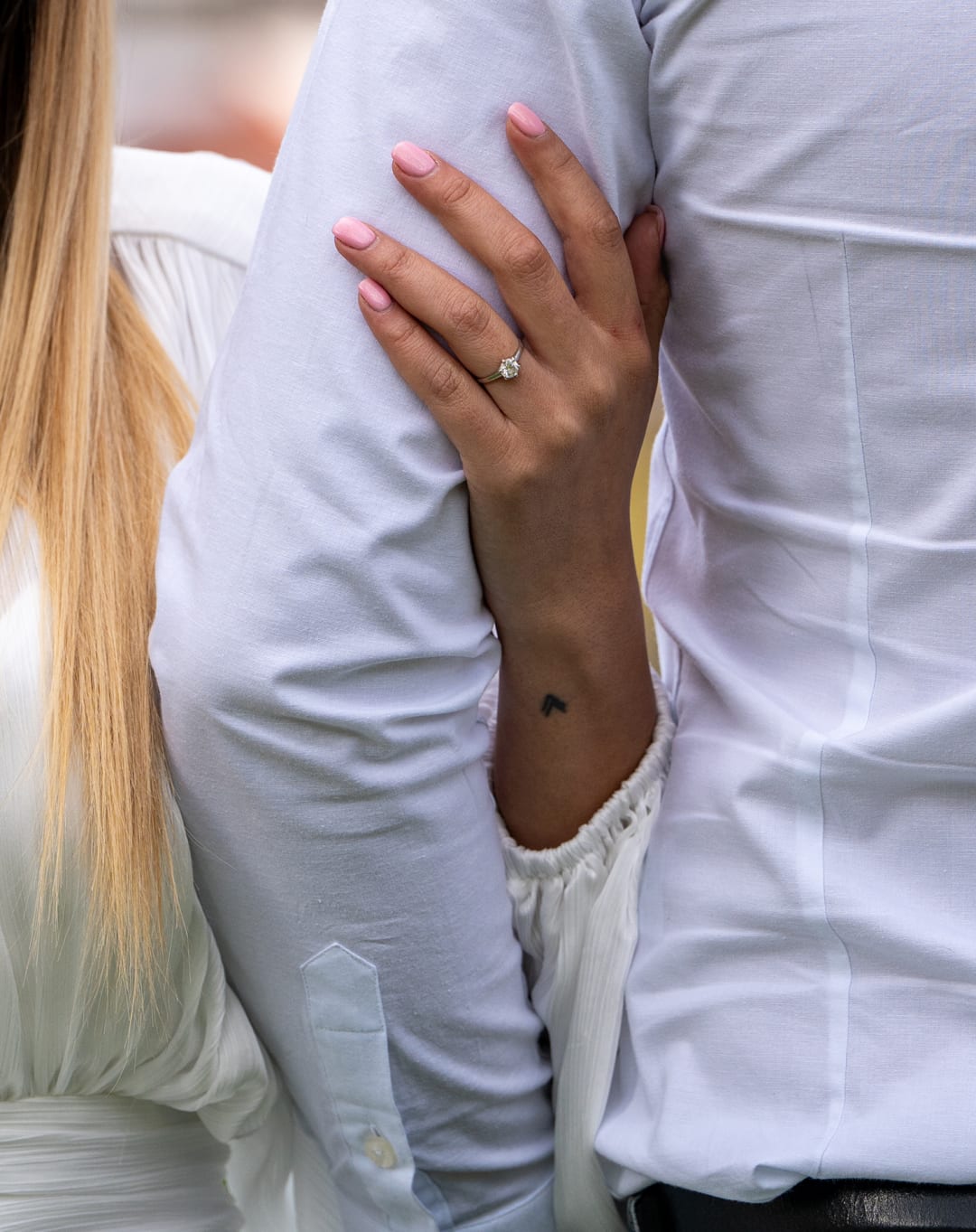 Engagement ring, intertwined hands