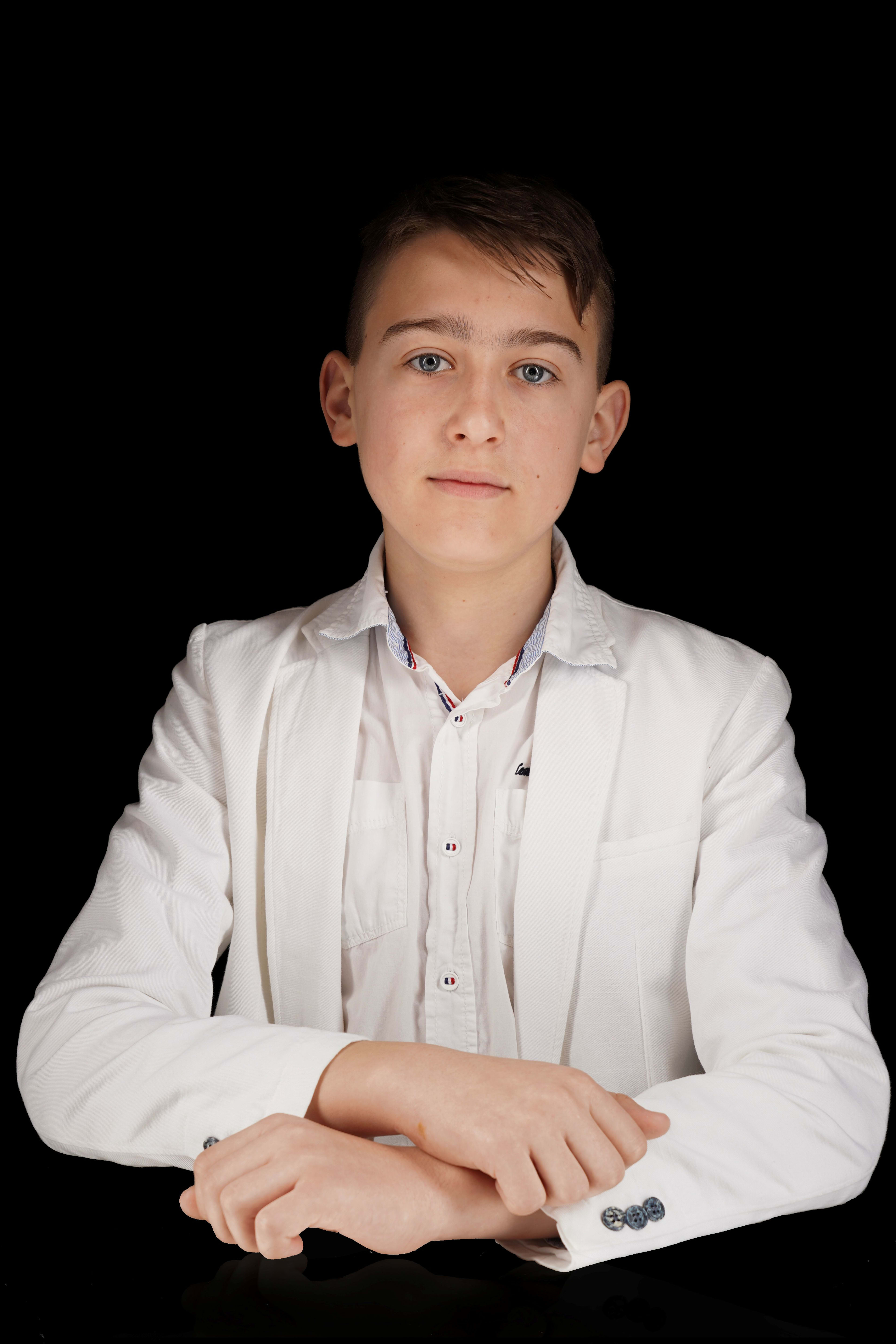 Boy in white suit against black background